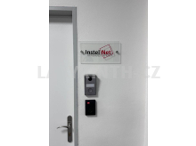 Skleněná tabulka u dveří kanceláře na dvou nerezových distancích